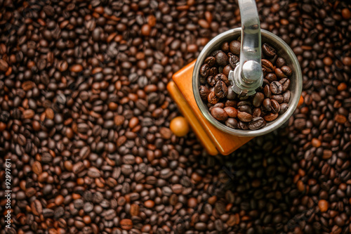 Hand grinder on roasted coffee beans background
