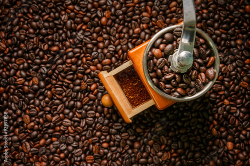 Hand grinder on roasted coffee beans background