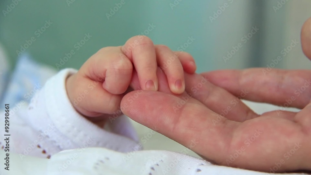 Hand in hand. Mother and newborn daughter in maternity hospital Hand in hand. Mother and newborn daughter in maternity hospital
