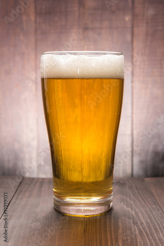 Glass of beer on the wooden background