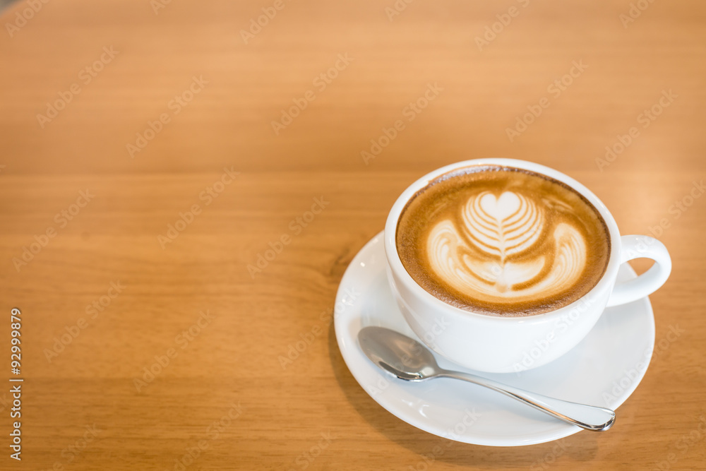 Hot art Latte Coffee in a cup on wooden table and Coffee shop bl Hot art Latte Coffee in a cup on wooden table and Coffee shop bl
