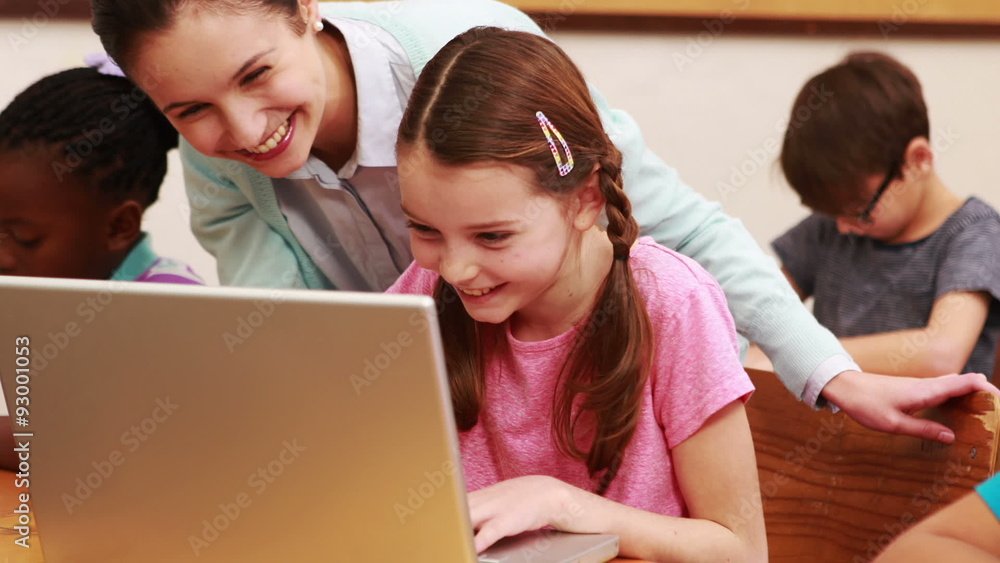 Teacher helping pupil with laptop Teacher helping pupil with laptop