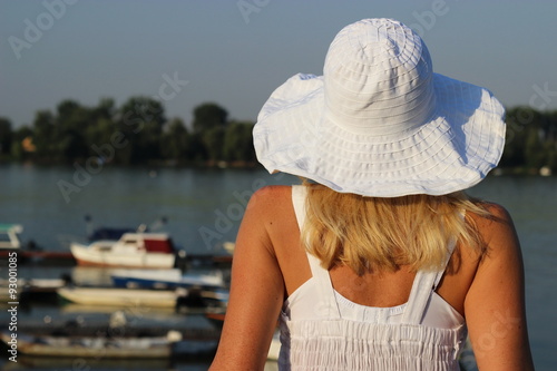  A woman with a hat relaxes by the river  © gojalia