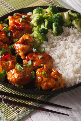 General Tso's chicken with rice, onions and broccoli closeup. vertical
 photo