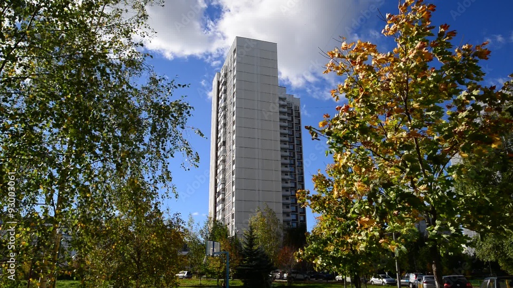 High-rise apartment building surrounded by autumnal trees High-rise apartment building surrounded by autumnal trees