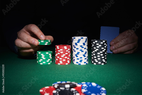 Poker chips on table with hands and cards