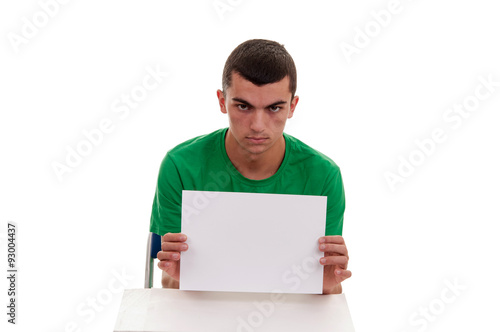 Young man sitting on a chair and holding white blank billboard i