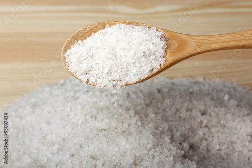 sea salt and wooden spoon on wooden background