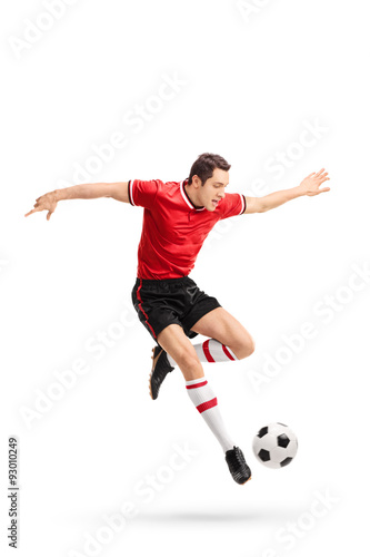 Young football player kicking a ball in mid-air © Ljupco Smokovski