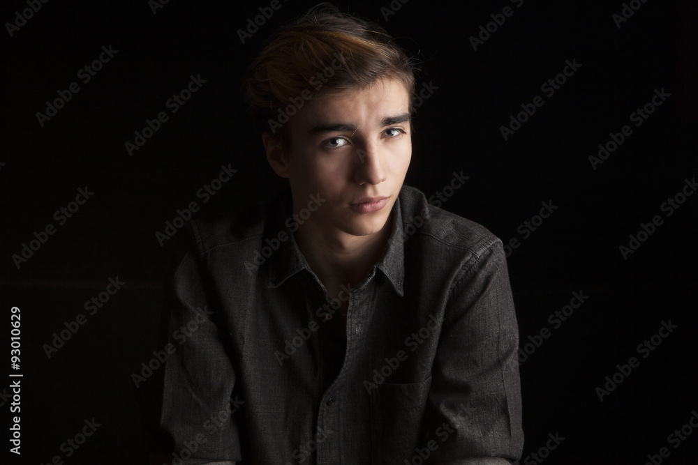 portrait of a young handsome man on black background