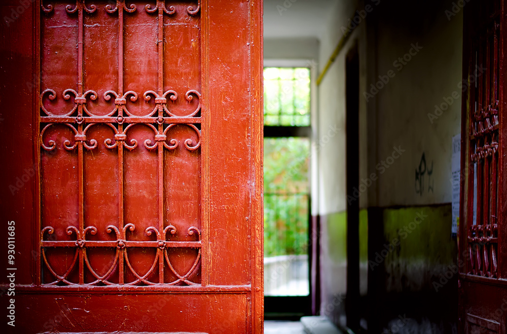 Red door detail with wrought iron ornaments Red door detail with wrought iron ornaments