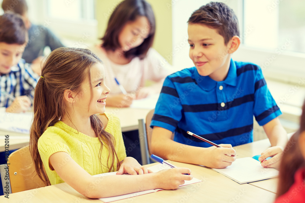 group of school kids writing test in classroom group of school kids writing test in classroom
