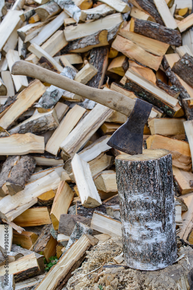 Old axe in log on a firewood background. Shallow depth of field, Old axe in log on a firewood background. Shallow depth of field,