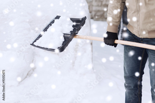 closeup of man digging snow with shovel near car