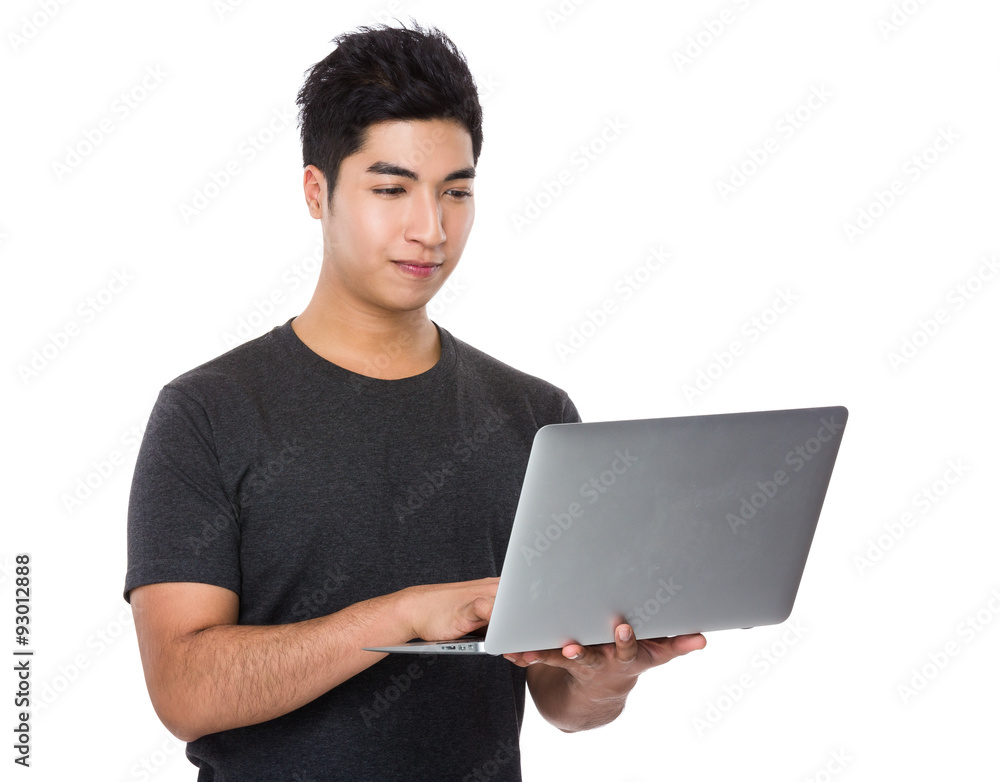 Asian young man use of the notebook computer Asian young man use of the notebook computer