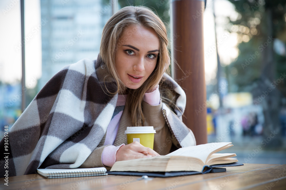 Portrait of a happy girl sitting with book in cafe Portrait of a happy girl sitting with book in cafe