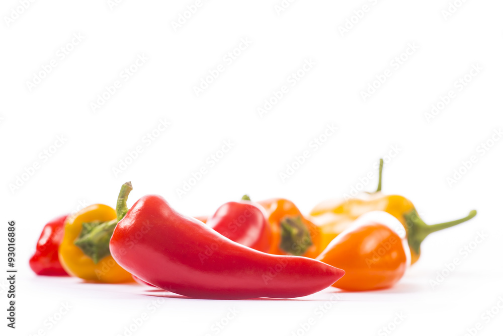 Red, yellow and orange pepper on white background