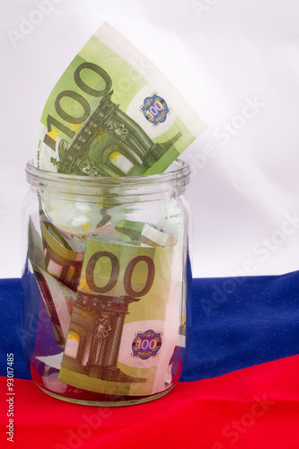 glass jar with dollars on the Russian flag