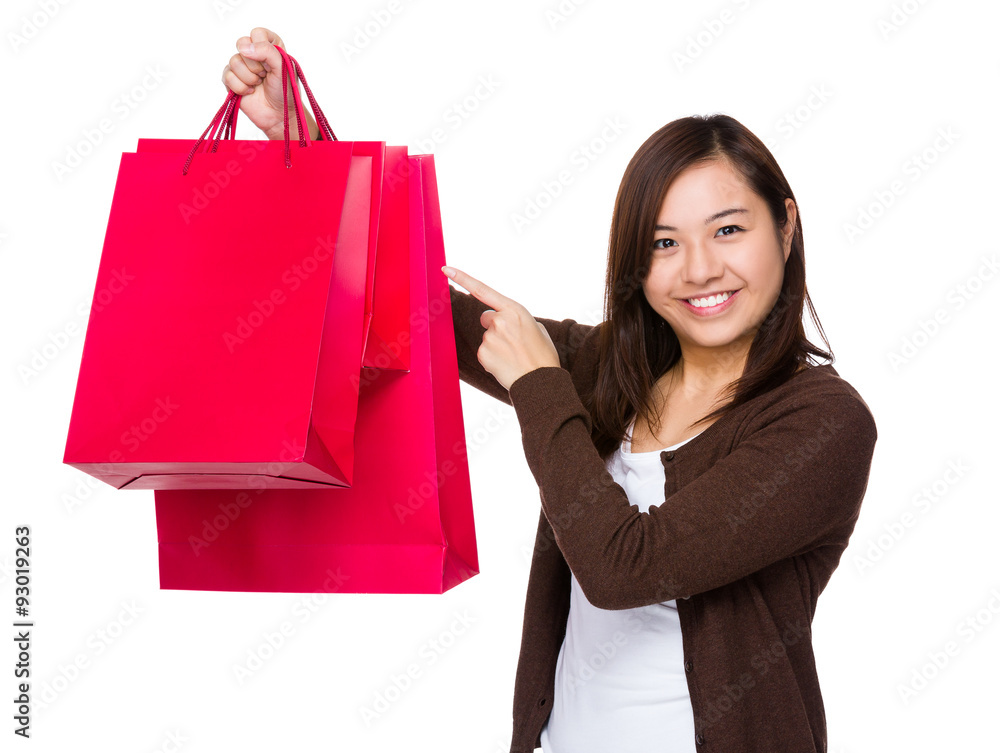 Asian woman finger point to shopping bag Asian woman finger point to shopping bag