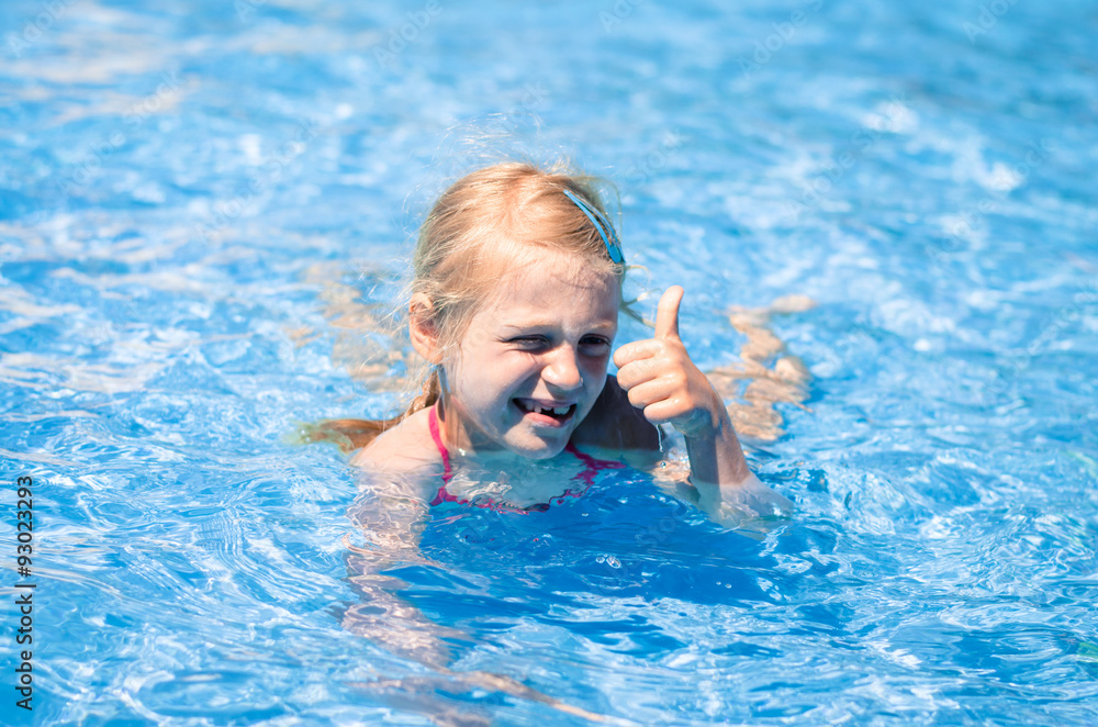 child in the water with thumb up