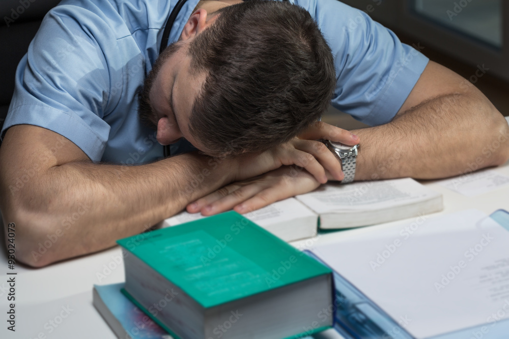 Tired doctor sleeping on desk Tired doctor sleeping on desk