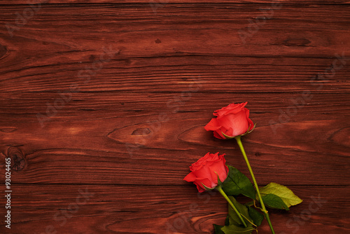 two roses over wooden brown backgorund