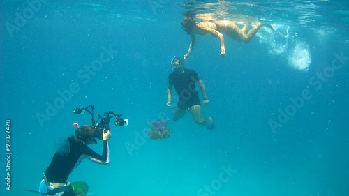 Underwater photographer shooting Underwater photographer shoots a man and a woman on the background of a Cauliflower jellyfish (Cephea cephea) 
 photo