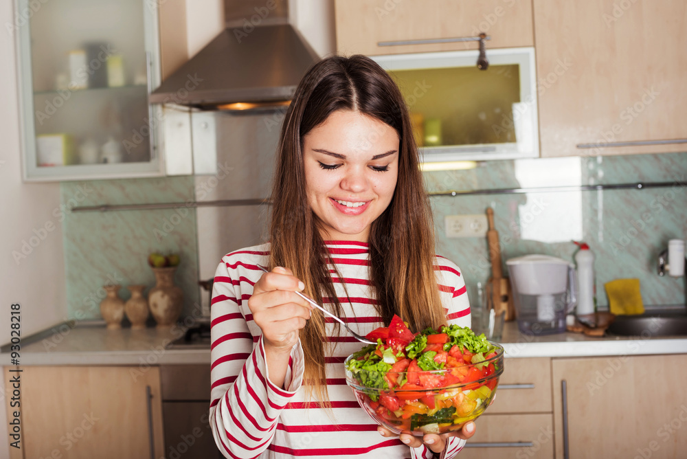 young caucasian female eating salad on kitchen. Healthy organic young caucasian female eating salad on kitchen. Healthy organic