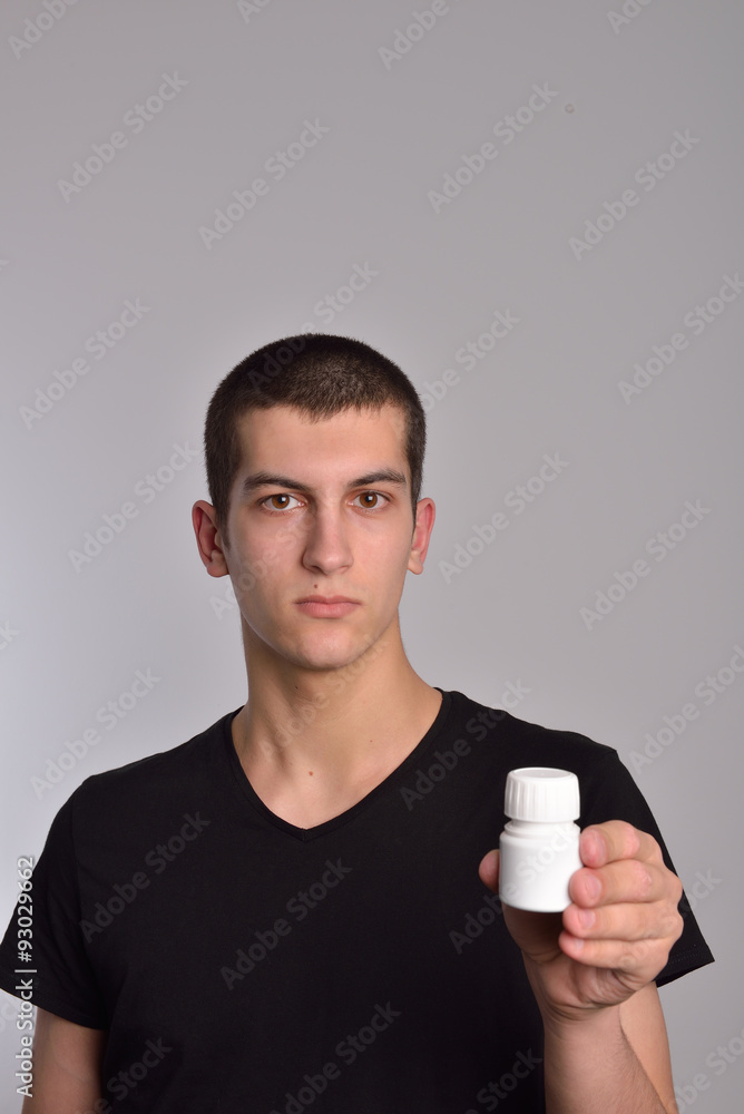 Young man holding a box of pills in his hand and shows the drugs Young man holding a box of pills in his hand and shows the drugs
