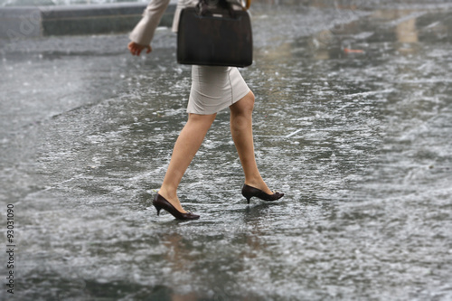 Woman walk on rain water  female feet with heels shoes walk on water when it rains