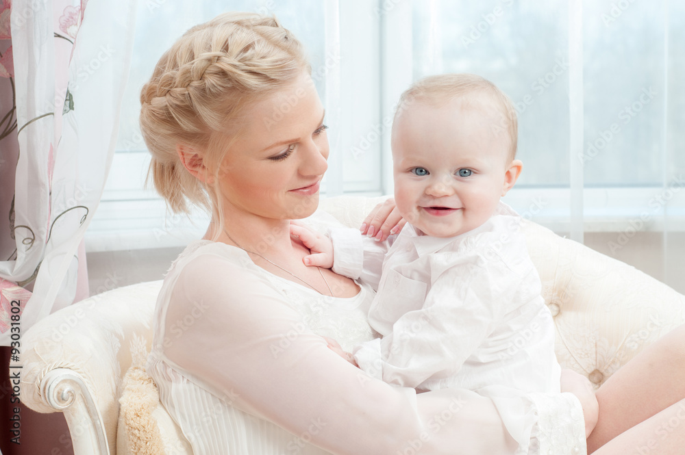 Mother and baby playing and smiling. Happy family.Home interior. Mother and baby playing and smiling. Happy family.Home interior.