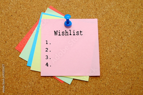 Wishlist written on color sticker notes over cork board background.