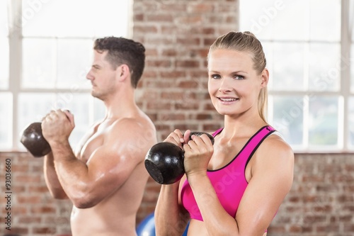 muscular smiling couple with kettlebells © WavebreakMediaMicro