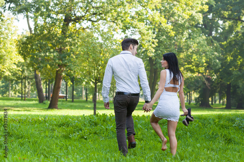 young couple taking a walk through the park