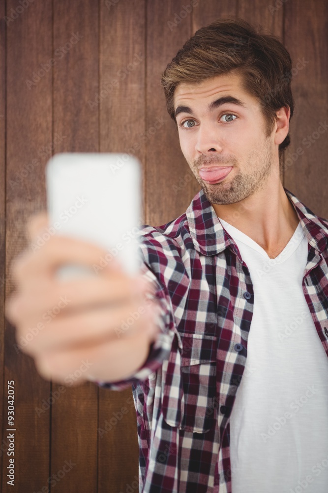 Hipster making face while taking selfie Hipster making face while taking selfie