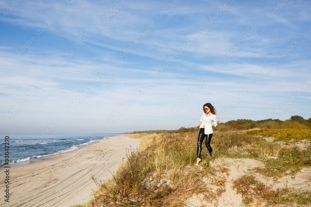 Young woman walking on the seacoast Young woman walking on the seacoast