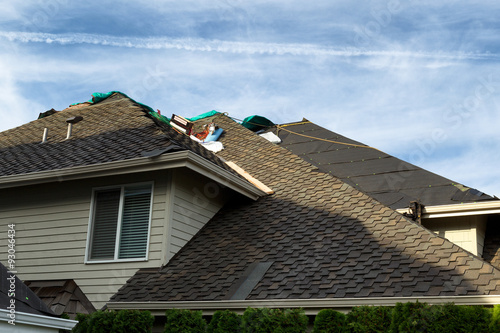Картината върху платно Home roof being replaced with new composite roofing materials