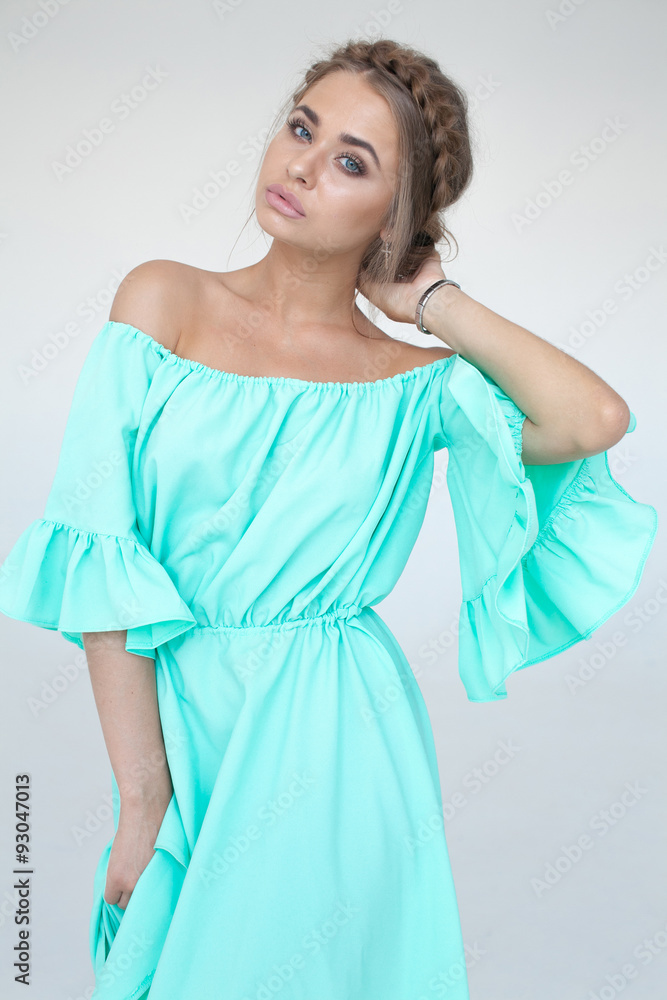 Portrait of beautiful woman with makeup and hairstyle in a turquoise dress Portrait of beautiful woman with makeup and hairstyle in a turquoise dress