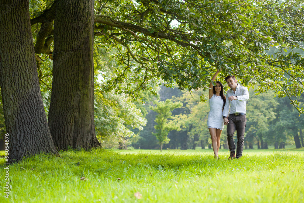 happy couple under tree in park happy couple under tree in park