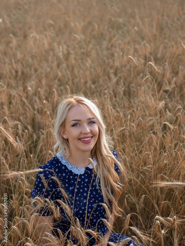Young woman enjoying nature and sunlight in straw field