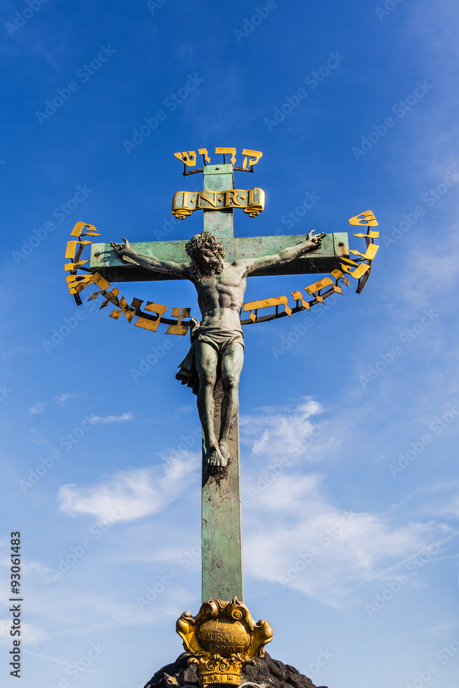 Ancient sculpture of Jesus Christ crucified on the Charles Bridge in Prague, Czech Republic.