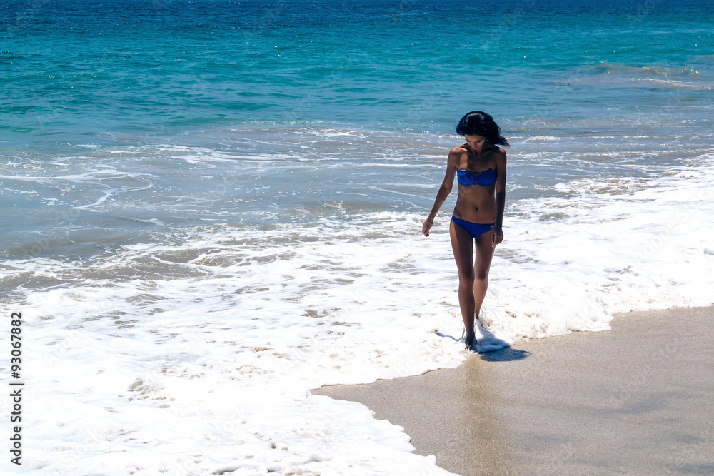 A girl walks on the beach