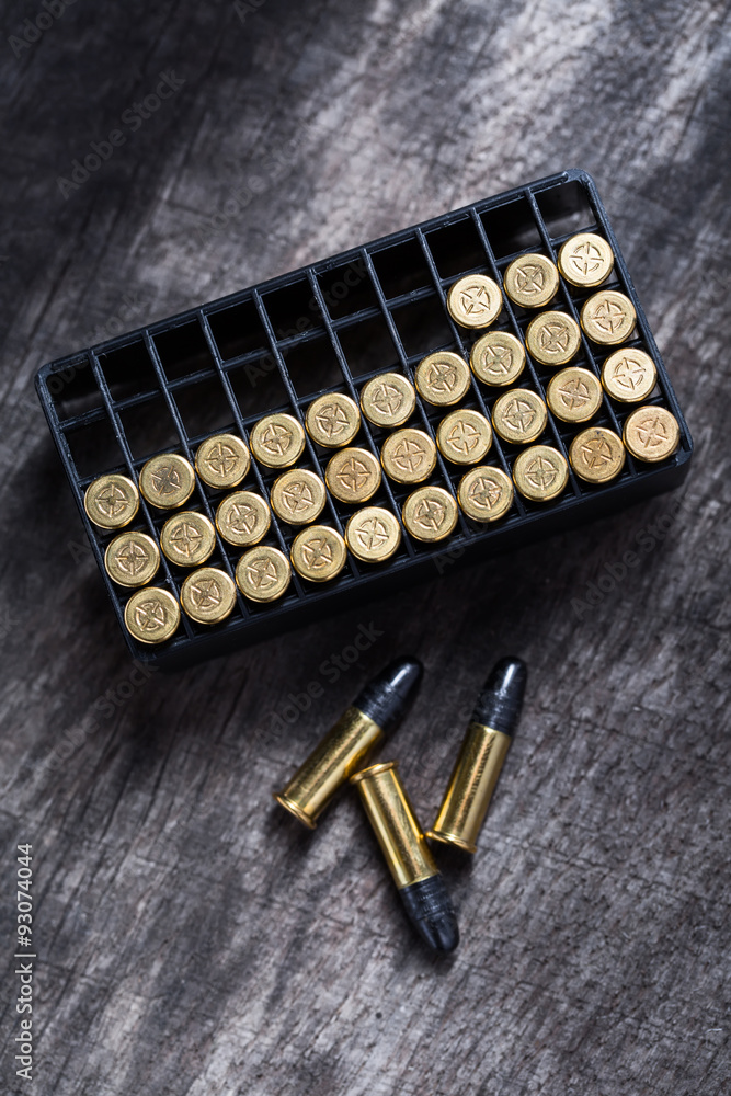 Scattering of small caliber cartridges on a wooden background Scattering of small caliber cartridges on a wooden background