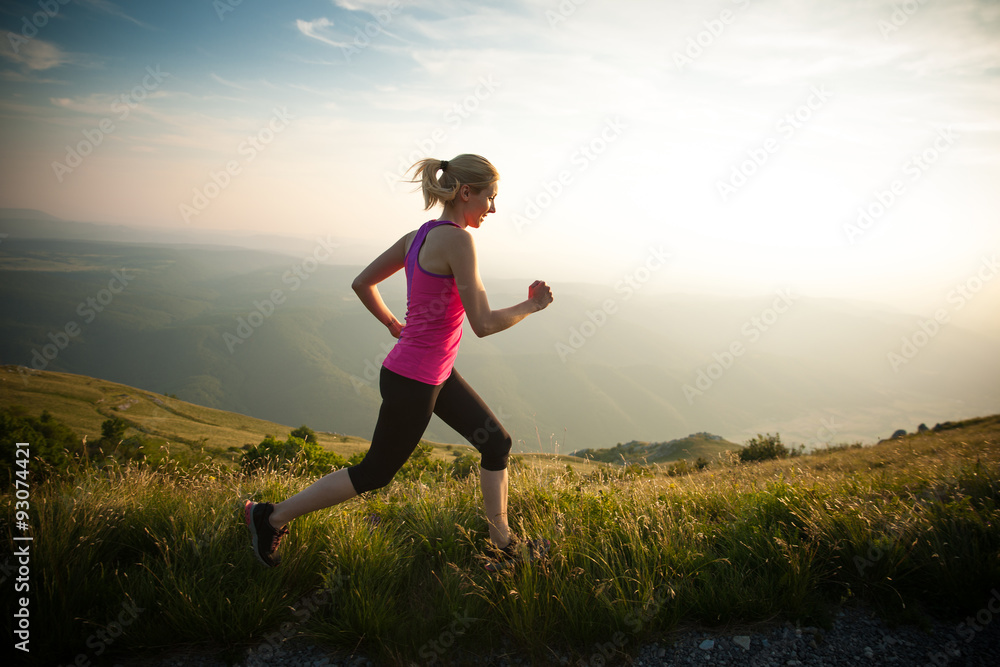 beautiful young woman runns cross country on a mountian path at beautiful young woman runns cross country on a mountian path at