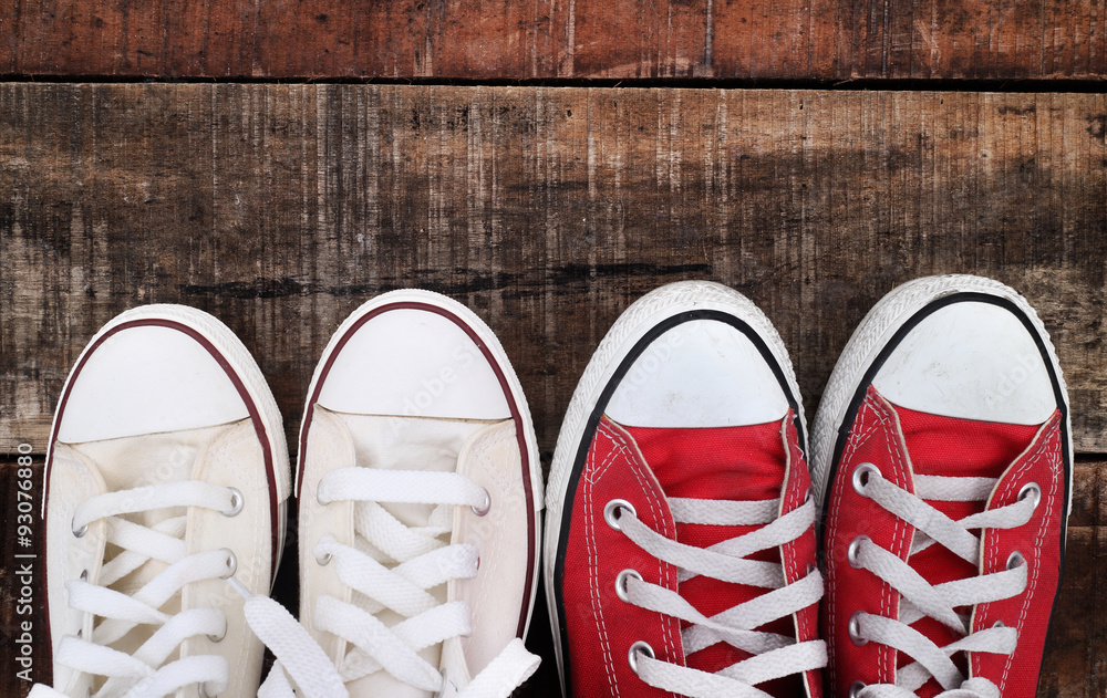Original Valentine's Day love concept with red and white sneakers. Studio shot on a wooden floor background. Original Valentine's Day love concept with red and white sneakers. Studio shot on a wooden floor background.