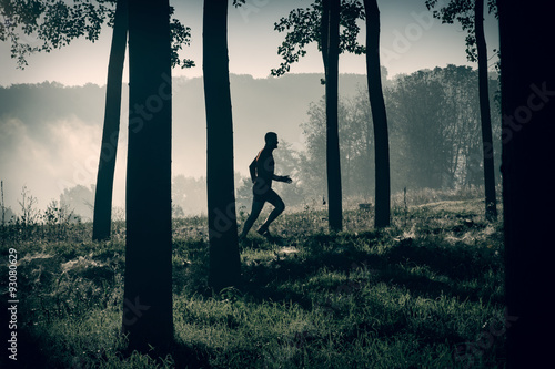 Man running on a path in a forest photo