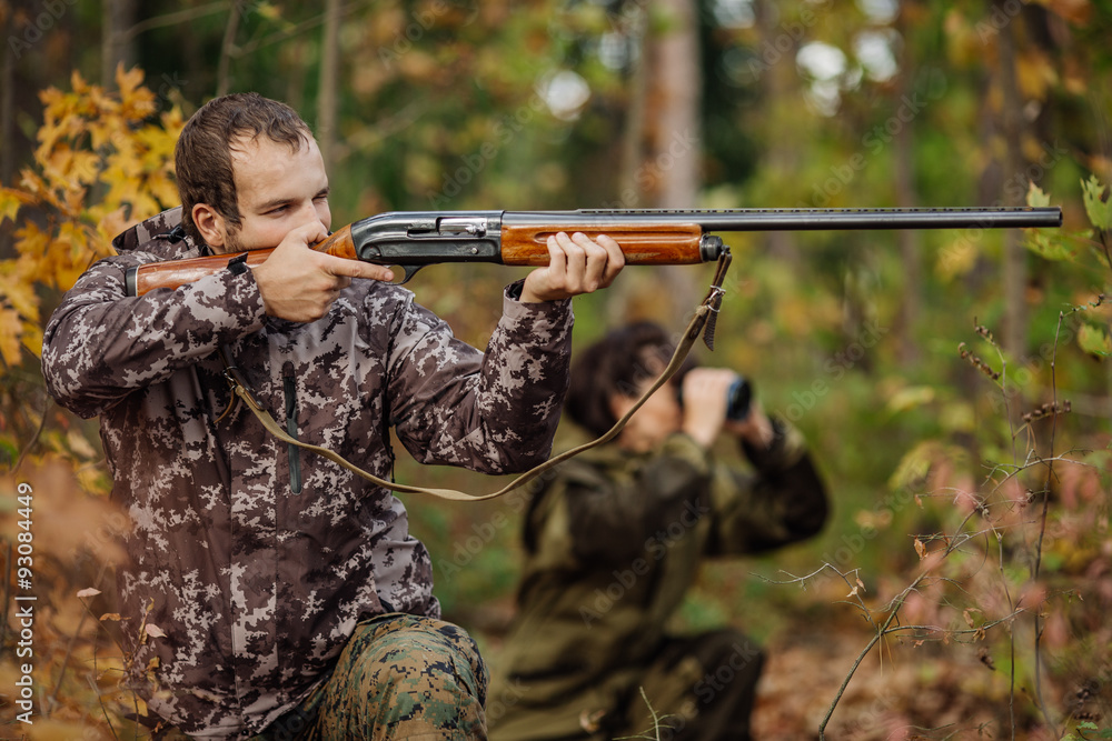 Fototapeta premium Instructor with woman hunter aiming rifle at firing nature
