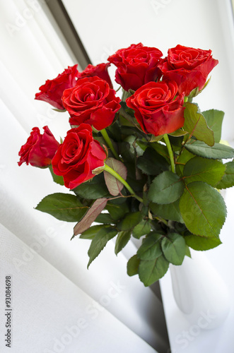 Red roses. A bouquet of flowers in the vase isolated on the white background. Festive backdrop, banner template with copy space. Happy birthday. Selective focus photo