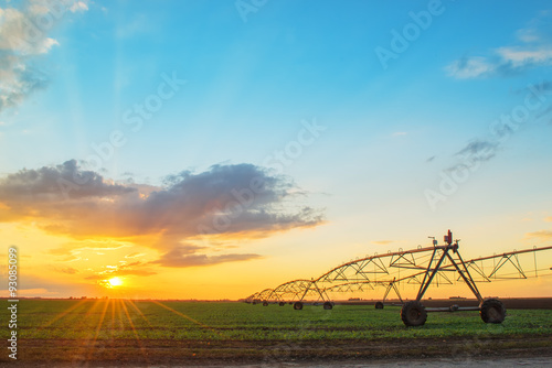 Automated farming irrigation system in sunset
