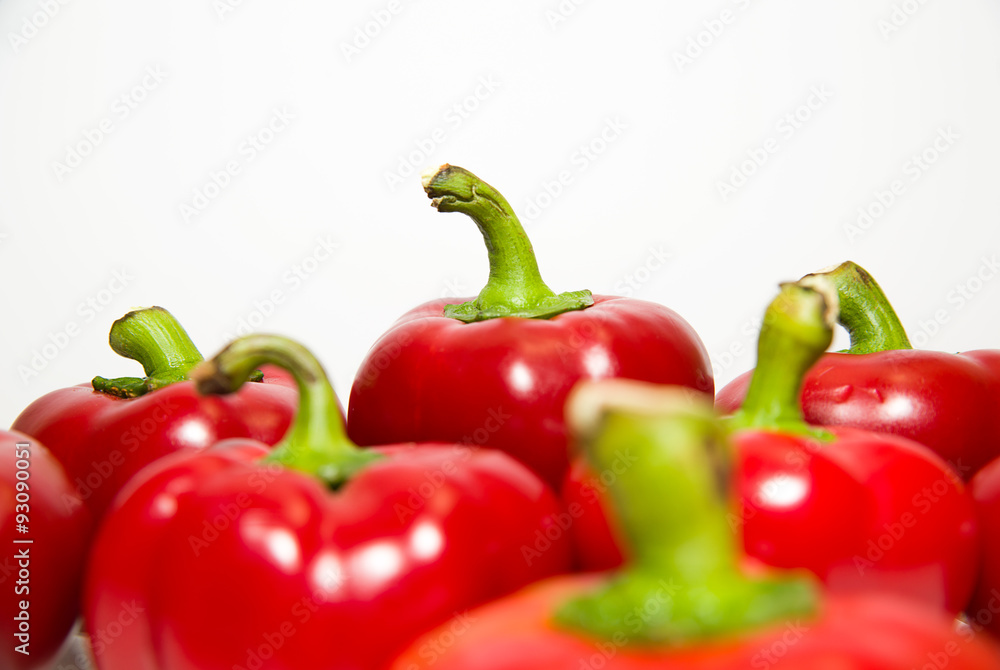 Many ripe red peppers on over white Many ripe red peppers on over white